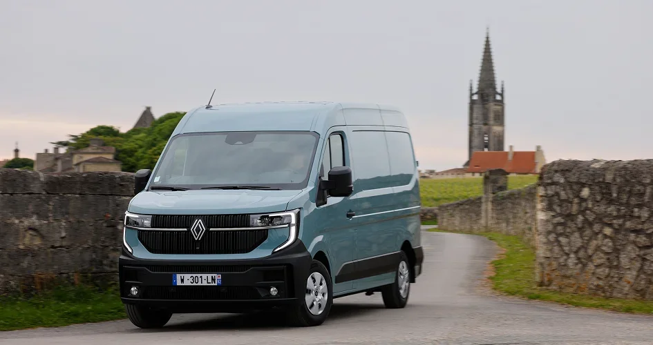 Fourgon utilitaire Renault bleu sur une route de campagne.